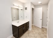 Thumbnail 5 of 28 - A bathroom with a sink, mirror, and cabinets.