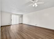 Thumbnail 53 of 74 - A room with a ceiling fan and wooden flooring.