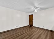 Thumbnail 55 of 74 - A room with a wooden floor and a ceiling fan.