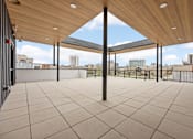 Thumbnail 9 of 52 - A patio with a wooden roof and tiled floor.