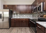 Thumbnail 7 of 43 - a kitchen with wooden cabinets and stainless steel appliances at 5Fifty5, Iowa, 50309