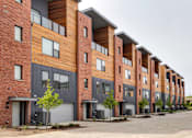 Thumbnail 24 of 43 - a row of brick apartment buildings with a sidewalk in front of them at 5Fifty5, Des Moines, IA 50309  