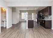 Thumbnail 31 of 43 - an empty kitchen with wood flooring and stainless steel appliances at 5Fifty5, Des Moines  
