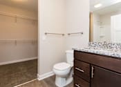 Thumbnail 8 of 43 - a bathroom with a toilet and a sink and a mirror at 5Fifty5, Des Moines, IA  
