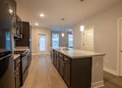Thumbnail 12 of 65 - A modern kitchen with dark wood cabinets and a large island.