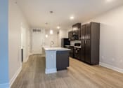 Thumbnail 22 of 65 - A kitchen with a white island and dark brown cabinets.