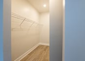 Thumbnail 23 of 65 - A hallway with a wooden floor and white walls.