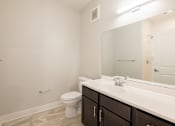 Thumbnail 21 of 65 - A white toilet sits next to a sink in a bathroom.