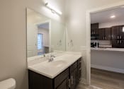 Thumbnail 30 of 65 - A bathroom with a white sink and a large mirror.