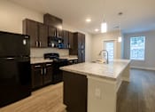 Thumbnail 25 of 65 - A kitchen with black appliances and brown cabinets.