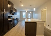 Thumbnail 28 of 65 - A kitchen with dark brown cabinets and a light brown island.
