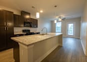 Thumbnail 26 of 65 - A kitchen with a granite countertop and dark brown cabinets.