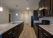 Thumbnail 3 of 65 - A kitchen with dark wood cabinets and granite countertops.