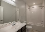 Thumbnail 15 of 65 - A white sink with a mirror above it and a toilet next to it.