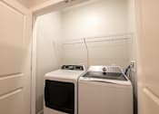 Thumbnail 14 of 65 - A small laundry room with a washer and dryer.