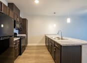Thumbnail 43 of 65 - A kitchen with dark wood cabinets and a granite countertop.