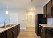 Thumbnail 42 of 65 - A kitchen with black appliances and wooden cabinets.