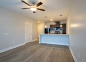 Thumbnail 45 of 65 - A room with a ceiling fan and a kitchen island.