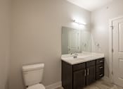 Thumbnail 39 of 65 - A white toilet sits next to a sink in a bathroom.