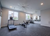 Thumbnail 57 of 65 - A spacious room with a treadmill, exercise bike, and other workout equipment.