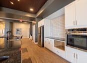 Thumbnail 64 of 65 - A kitchen with white cabinets and a black counter top.