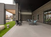 Thumbnail 51 of 65 - A patio with a table and chairs is surrounded by a brick wall.