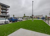 Thumbnail 54 of 65 - A leasing office is located in a building next to a parking lot with cars parked in it.