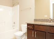 Thumbnail 8 of 14 - Bathroom with granite counter tops a large mirror and a bathtub at 7th Street Brownstones, Indigo Living, Iowa