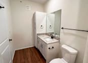 Thumbnail 13 of 51 - a bathroom with a toilet and a sink and a mirror at 92West, West Des Moines, IA  