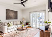 Thumbnail 3 of 60 - A living room with a white couch, a brown coffee table, and a painting on the wall.