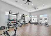 Thumbnail 24 of 51 - a gym with cardio machines and weights on a wooden floor at 92West, West Des Moines, IA 50266  