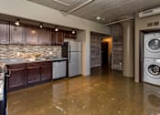 Thumbnail 2 of 23 - Kitchen with a washing machine and a washer in it at Ballyard Lofts, Indigo Living, IA, Iowa , 50309