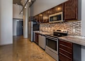 Thumbnail 1 of 23 - Kitchen with stainless steel appliances and wooden cabinets at Ballyard Lofts, Iowa
