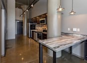 Thumbnail 3 of 23 - Kitchen with a marble counter top and a stainless steel at Ballyard Lofts, Indigo Living, IA, 50309