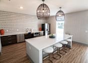 Thumbnail 19 of 23 - a kitchen with a white counter top and a dining table at Centennial Crossing, Waukee, Iowa