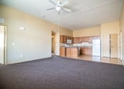 Thumbnail 7 of 16 - A spacious room with a ceiling fan and a kitchen area in the background.at Cottages at Johnston Commons, Iowa, 50131