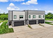 Thumbnail 32 of 34 - A modern two-story house with a garage on the ground floor.