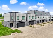 Thumbnail 27 of 34 - A row of modern buildings with garage doors.