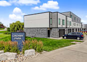 Thumbnail 30 of 34 - A modern building with a sign that reads "Crosby Park" in front of it.