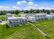 Thumbnail 31 of 34 - A large building complex with multiple structures and a green lawn in front.