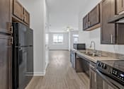 Thumbnail 45 of 52 - A kitchen with dark wood cabinets and stainless steel appliances.