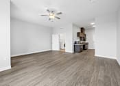 Thumbnail 24 of 52 - A room with a ceiling fan and light fixture, and a wooden floor.