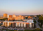 Thumbnail 20 of 65 - A modern building with a parking lot in front of it.
