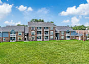 Thumbnail 48 of 53 - A large brick building with a green lawn in front.