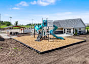 Thumbnail 43 of 53 - A playground with a slide and a building in the background.