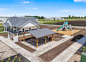 Thumbnail 37 of 53 - A playground with a slide and a building in the background.