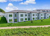 Thumbnail 50 of 53 - A row of white houses with green lawns in front.