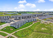 Thumbnail 53 of 53 - A large building complex with a green lawn in front.