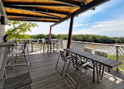 Thumbnail 36 of 42 - A wooden deck with tables and chairs overlooking a grassy area. at Eagle View Lofts, Iowa