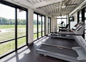 Thumbnail 29 of 42 - A treadmill in a room with a ceiling fan and large windows. at Eagle View Lofts, Iowa, 50309